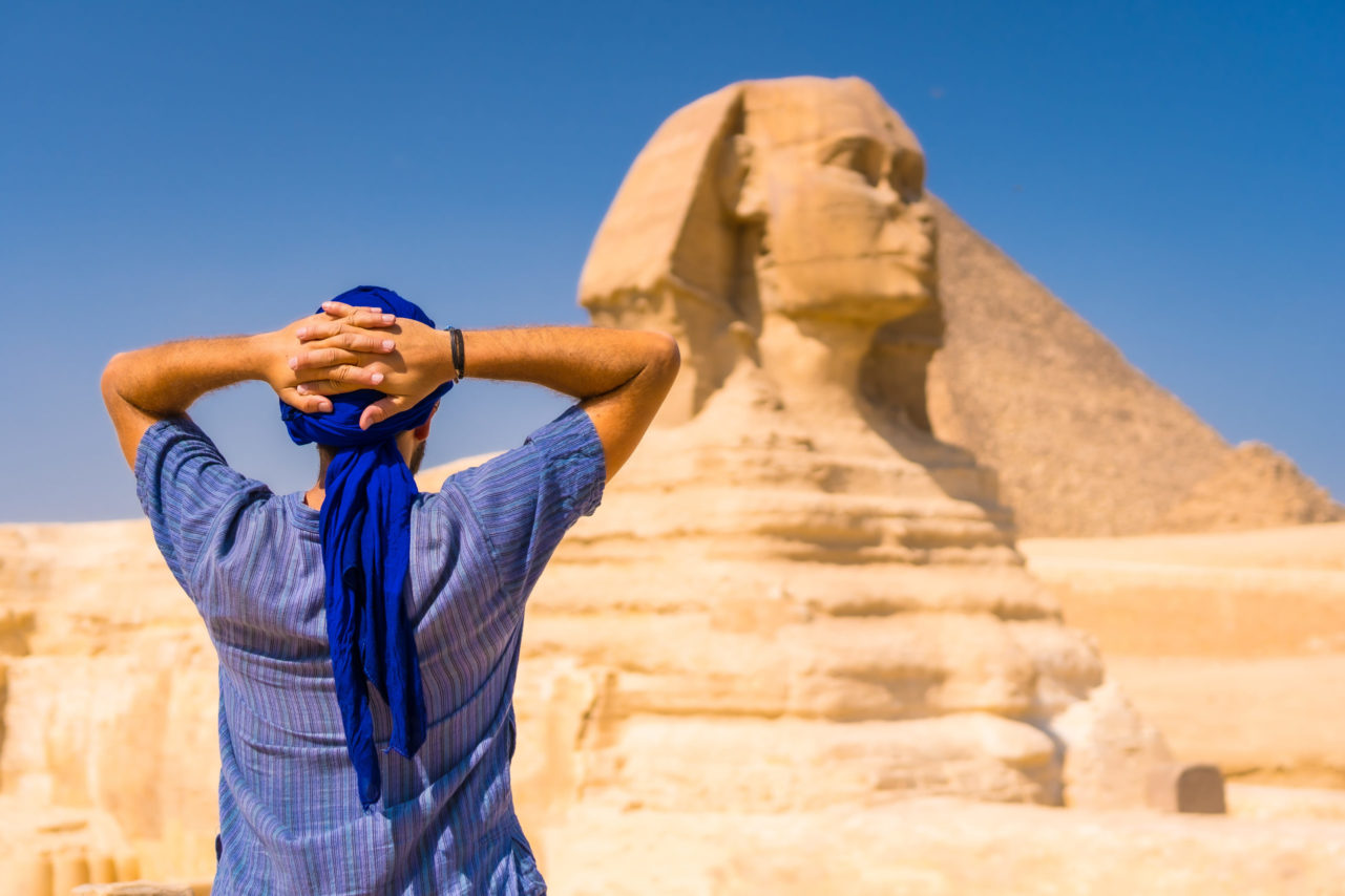 A young tourist wearing a blue turban standing near the Great Sphinx of Giza, Cairo, Egypt